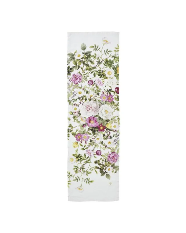 Ein schmaler Tischläufer aus Leinen mit üppigen Rosen- und Wildblumenmotiven in Rosa, Weiß und Grün auf hellem Grund. Die natürliche, leicht strukturierte Oberfläche des Leinens unterstreicht die zarte Eleganz des floralen Designs von Koustrup & Co.