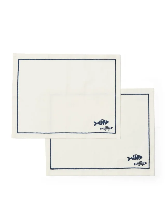 Como Catch 2er Tischsets von Rivièra Maison in weiß mit dunkelblauen Fischen drauf.