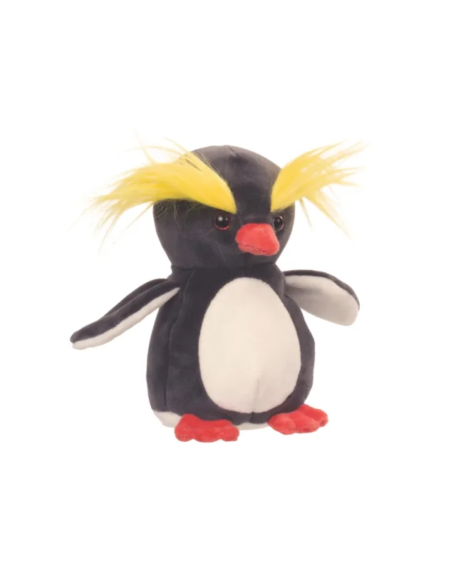 Ein Felsenpinguin mit markanten gelben Federkämmen, freundlichem Blick und roten Füßen. Das Kuscheltier „Crazy Crested“ von Bukowski steht aufrecht.