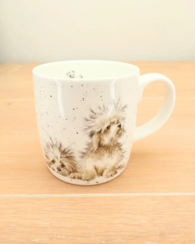 Die große Hunde-Tasse "Best of Friends" von Wrendale Designs steht auf einem Holztisch. Die beiden Hunde sind auf der Vorderseite zu sehen.