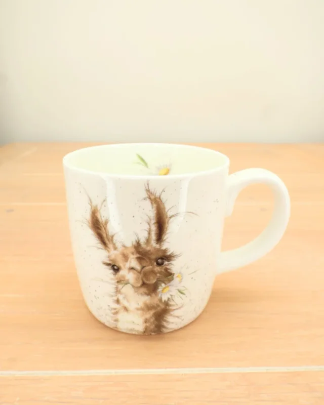 Die große Lama-Tasse "I'm worth it" von Wrendale Designs steht auf einem Holztisch. Das Lama mit dem Blumenkranz ist gut zu erkennen.