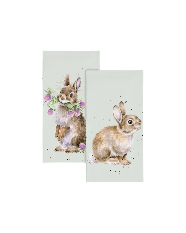 Zwei Kaninchen-Taschentücher von Wrendale Designs mit Illustrationen von Hannah Dale: ein Kaninchen mit lila Blumen im Maul und ein sitzendes Kaninchen – beide auf sanft graugrünem Hintergrund; die Taschentücher liegen vor weißem Hintergrund.