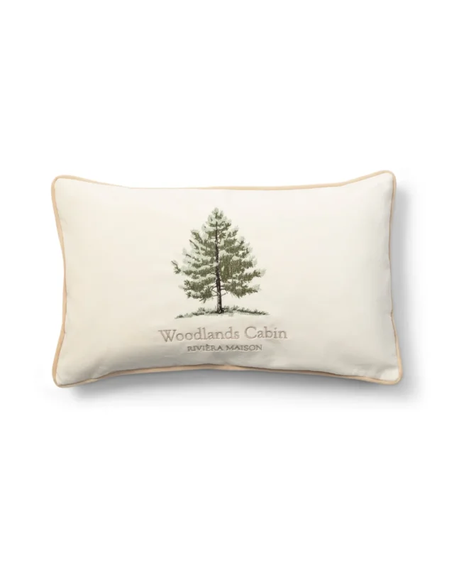Kissenbezug Forges Pillow Cover von Rivièra Maison mit gestickter Tanne auf beigem Stoff vor weißem Hintergrund.