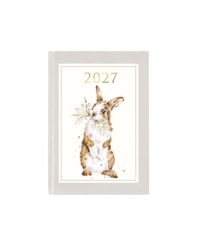 Kleiner Taschenkalender 2027 von Wrendale Designs vor weißen Hintergrund. Das Motiv zeigt einen weißen Hintergrund und ein Kaninchen welcher Blumen im Mund trägt.