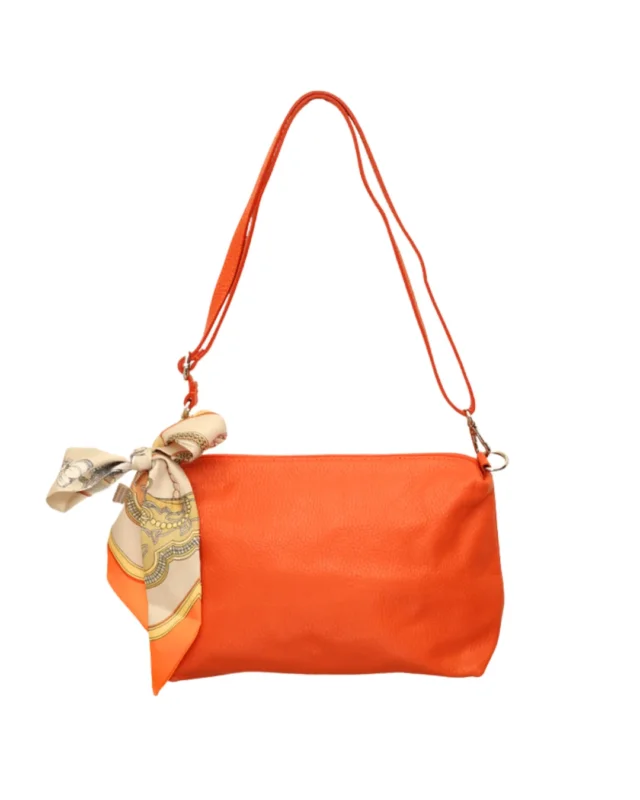 Orangene Leder Handtasche "Brigitte" von Südstrand vor weißen Hintergrund. Am Verschluss hängt ein größtenteils weiß/orangenes Tuch.