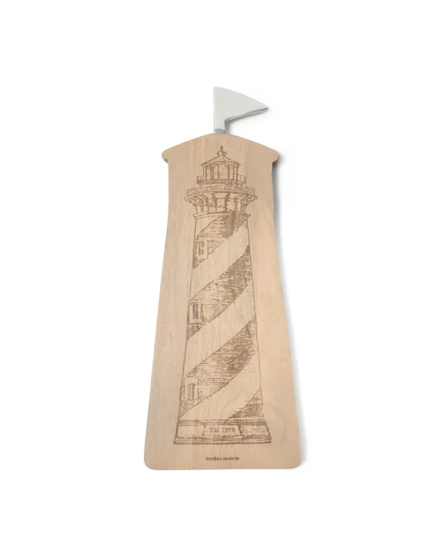 Leuchtturm Schneidebrett "Lighthouse Chopping Board" von Riviera Maison vor weißen Hintergrund. Das Schneidebrett hat eine Leuchtturm Form und ein aufgezeichneten Leuchtturm als Motiv in der Mitte.