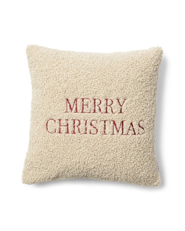 Cremefarbener Rivièra Maison Kissenbezug aus Teddystoff mit roter Merry Christmas Stickerei.