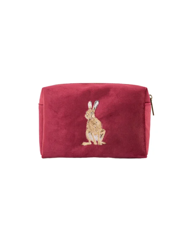 Bordeauxrote Schminktasche von Wrendale Designs mit gesticktem Hasenmotiv nach einer Illustration von Hannah Dale, freigestellt vor weißem Hintergrund.