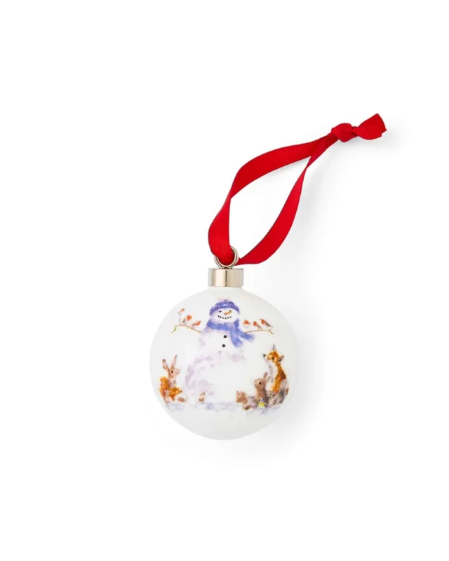 Schneemann Porzellankugel von Wrendale Designs mit rotem Satinband zum Aufhängen vor weißem Hintergrund.