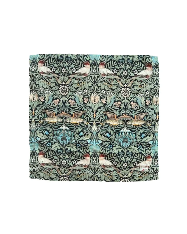 Eine Leinenserviette „William Morris Bird“ von Koustrup & Co. mit dem charakteristischen Muster aus Vögeln und Blumenranken auf weißem Hintergrund, inspiriert vom berühmten Künstler William Morris.